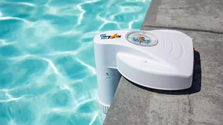 Blue Wave pool alarm in white on the edge of pool.