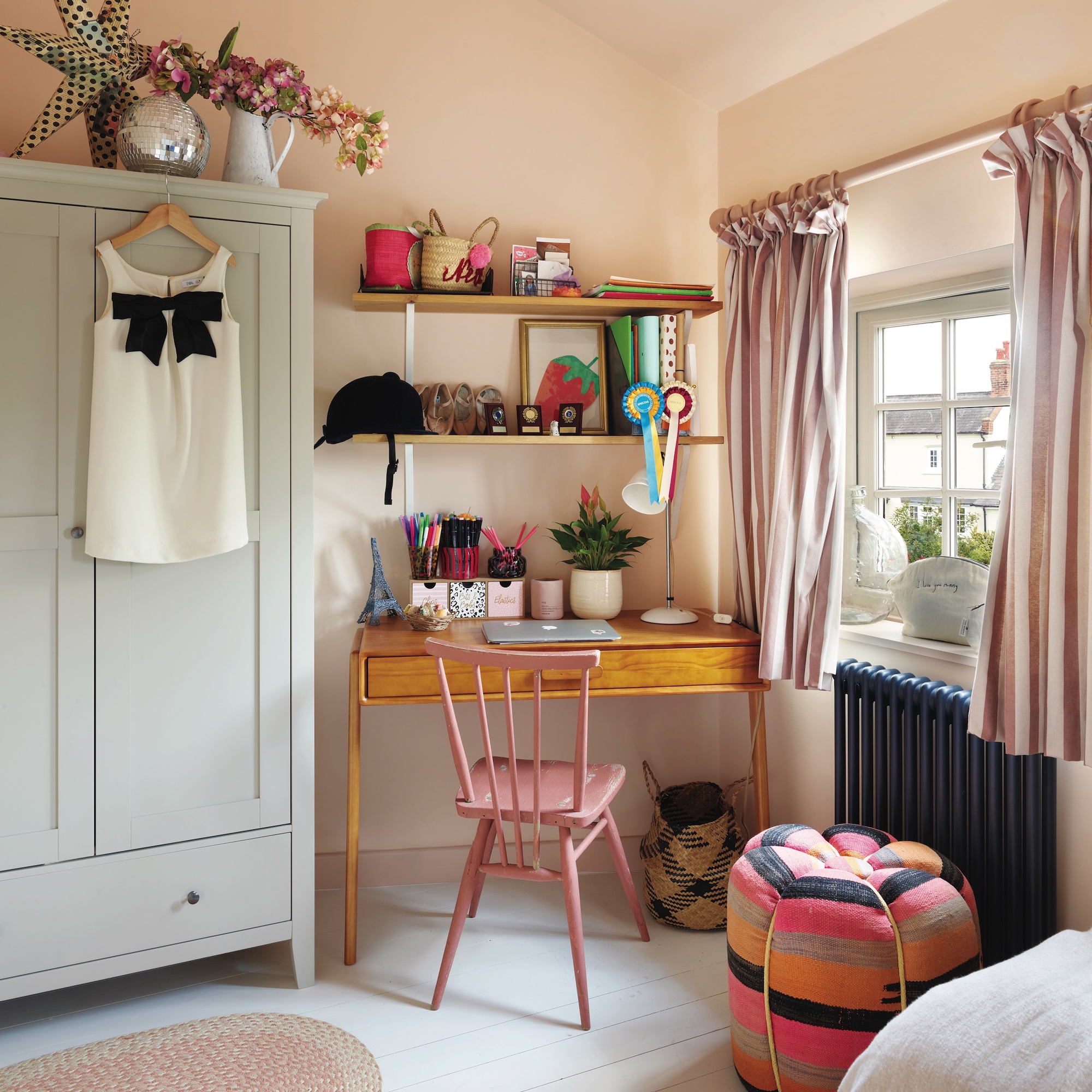 girls bedroom with desk and pink painted chair next to small wardrobe