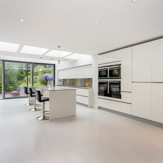 white kitchen with worktop and bar stools