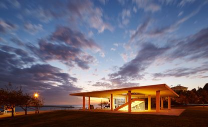 Minimalist structure with a flat roof, at sunset