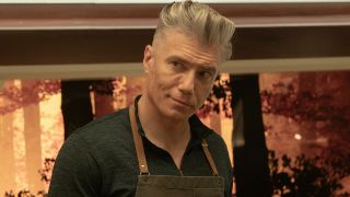 Pike working on a meal with an apron on.