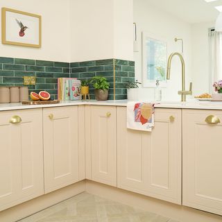 kitchen-diner with pink cabinets and sink and tap