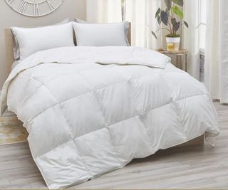 A white comforter on a bed.