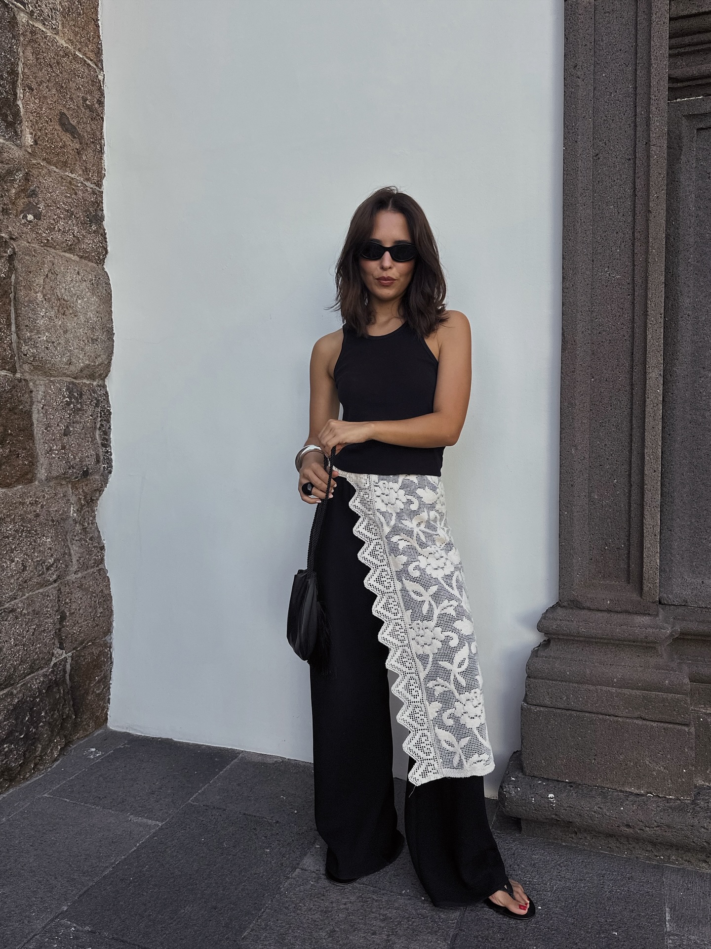 Debora in black satin trousers and lace skirt over top