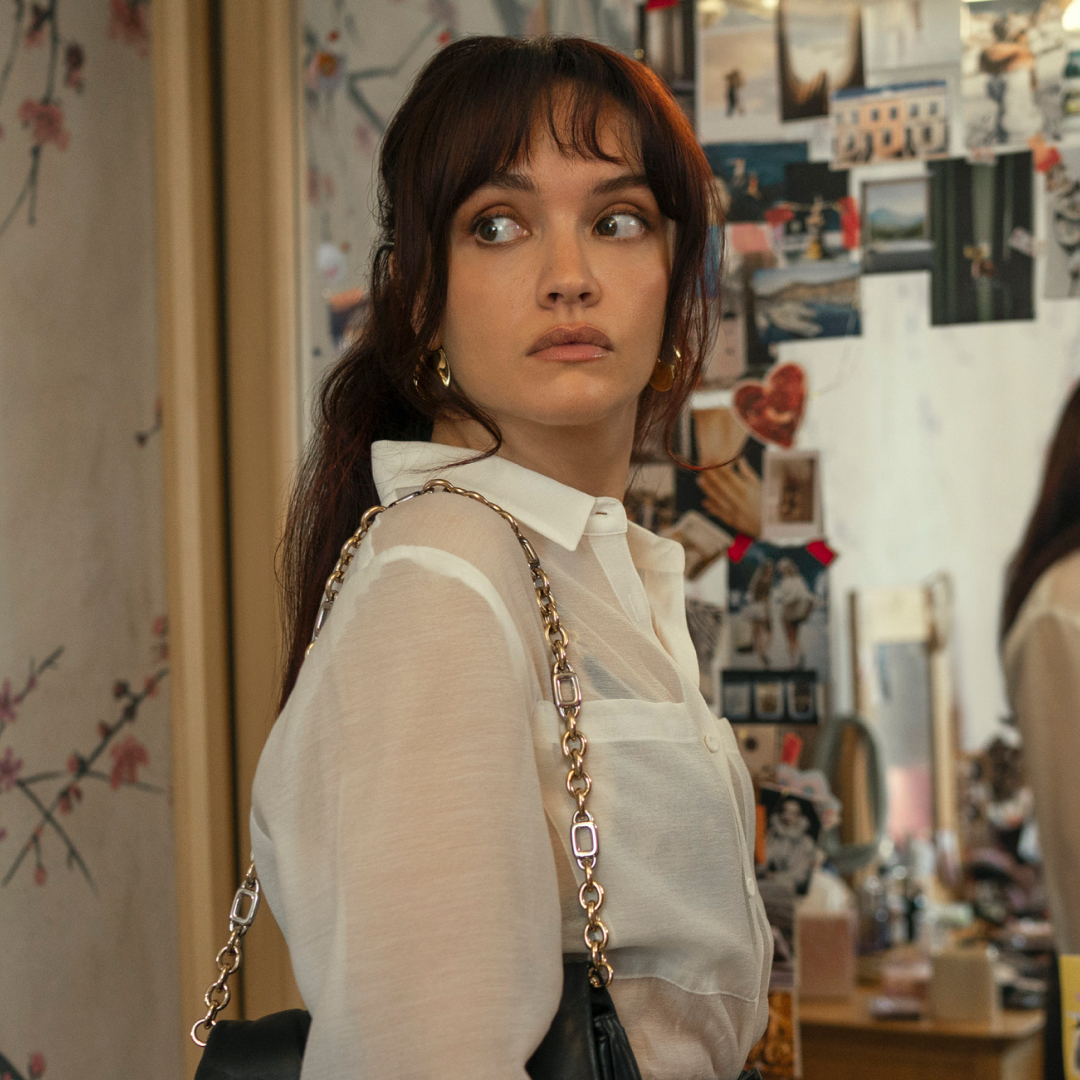 olivia cooke wearing a white blouse looking over her shoulder in the girlfriend prime video