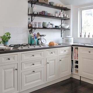 kitchen room with white cabinets and shelves on wall