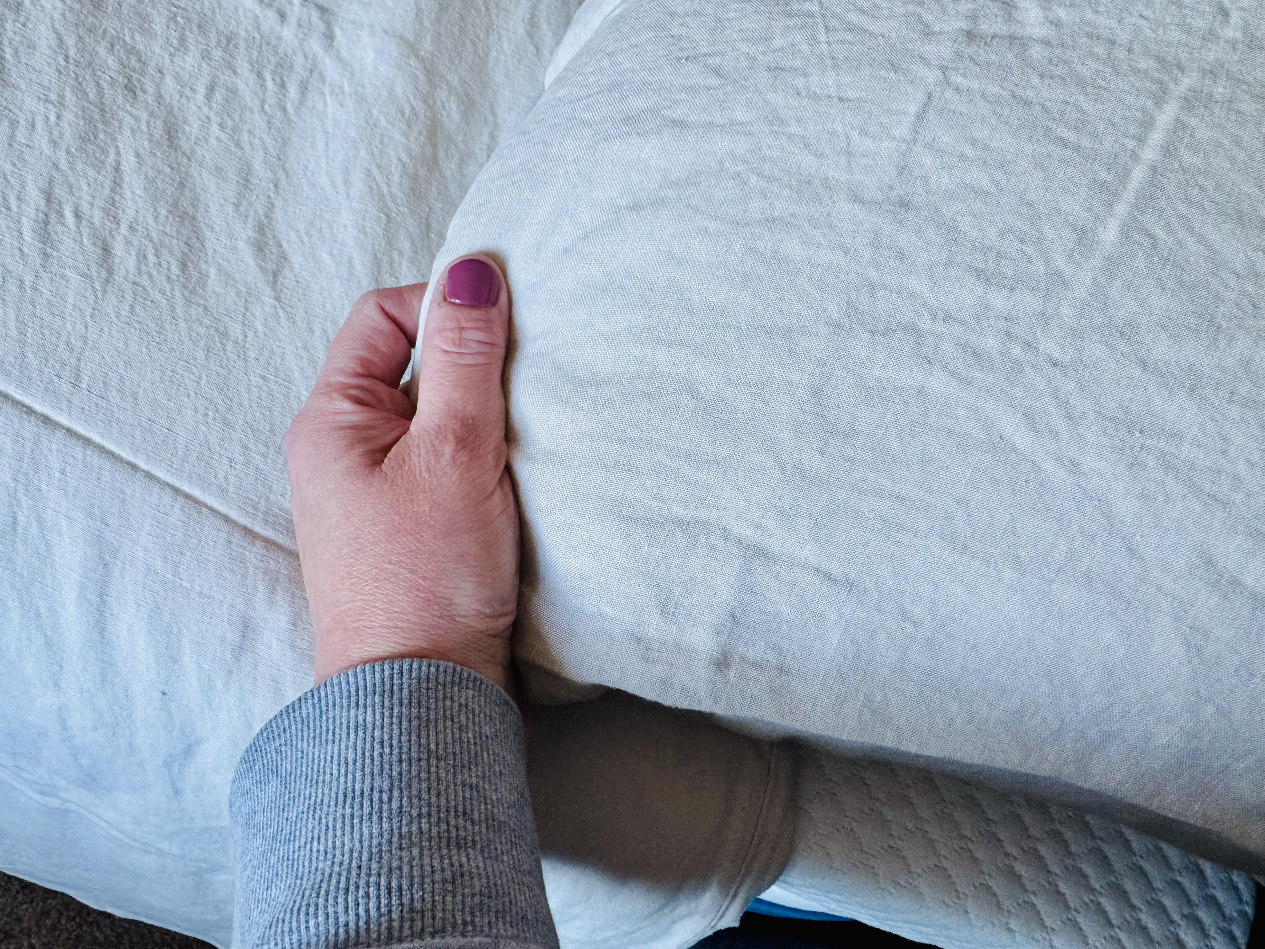 The Simba Cool Linen pillow case pictured alongside writer Heidi Scrimgeour's hand during testing
