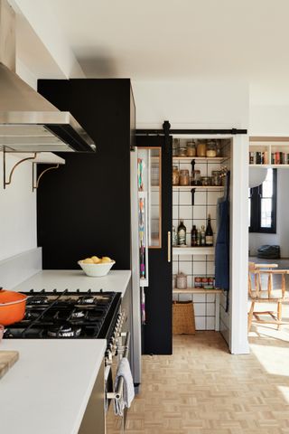 Black kitchen with small pantry