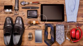A variety of men's accessories laying neatly on a wooden table.