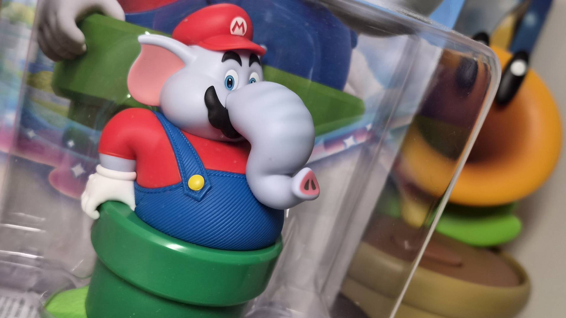 Photo of the Elephant Mario amiibo with a Talking Flower toy in the background.
