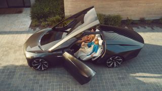 Side view of man and woman sitting in the Cadillac InnerSpace concept with doors open