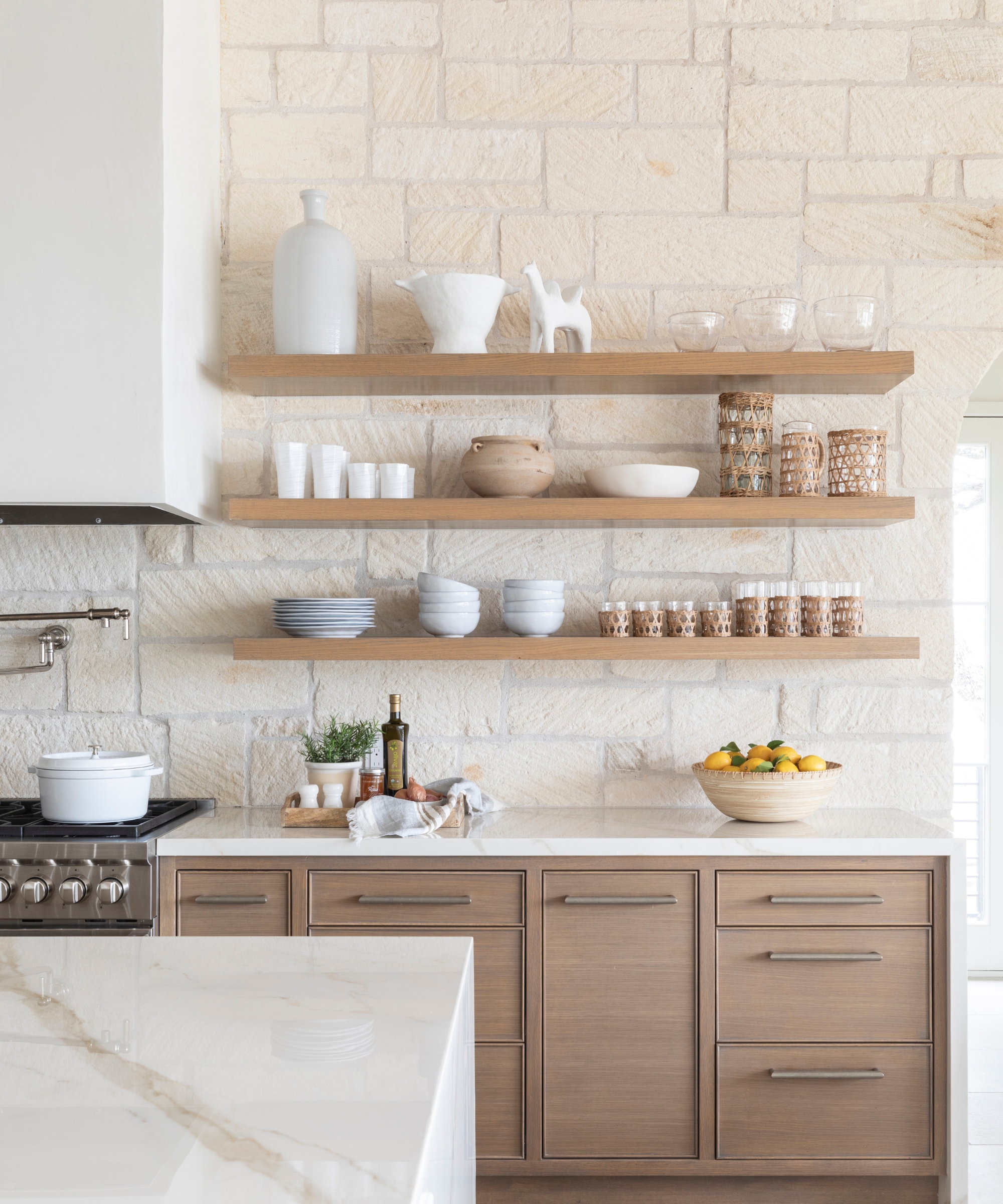 A wooden kitchen with an exposed white brick backsplash