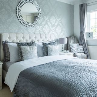 bedroom with grey bed and wallpaper