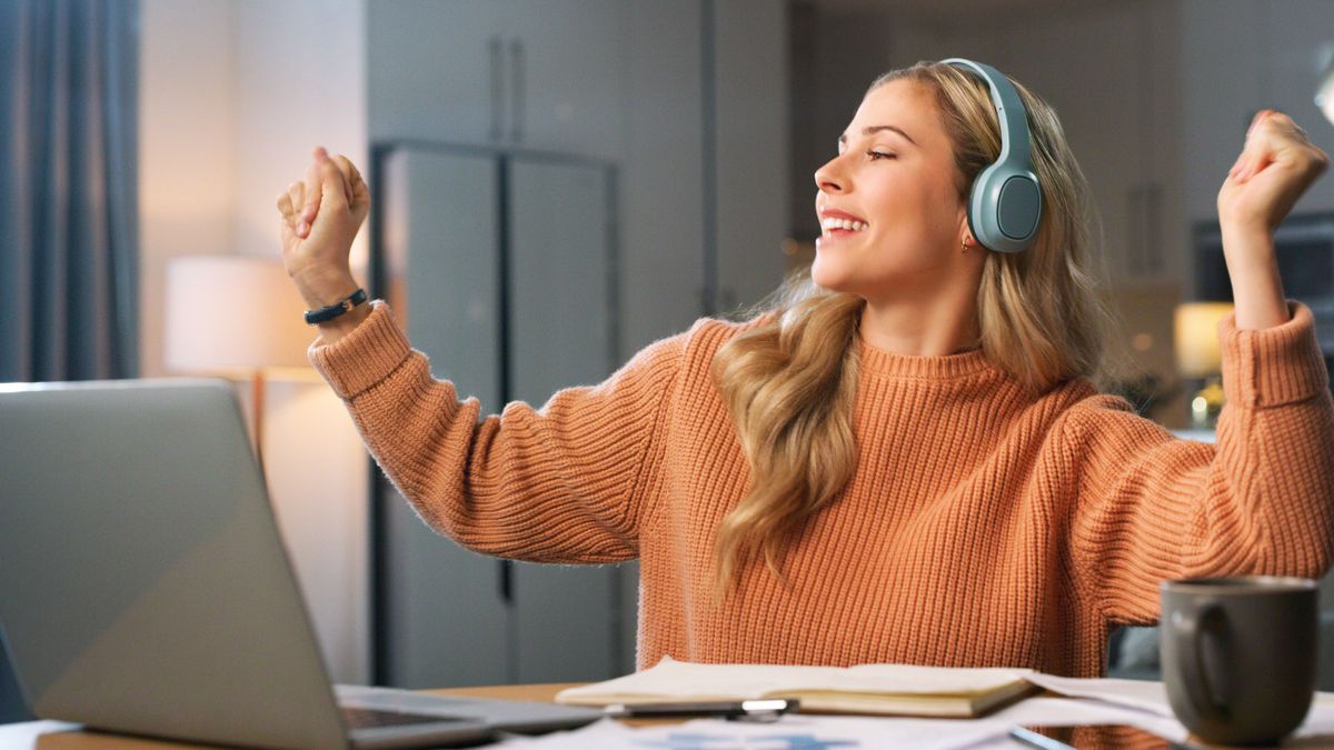 Young woman celebrating at laptop 