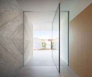 large glass pivot frameless door leading from inside corridor to outside area