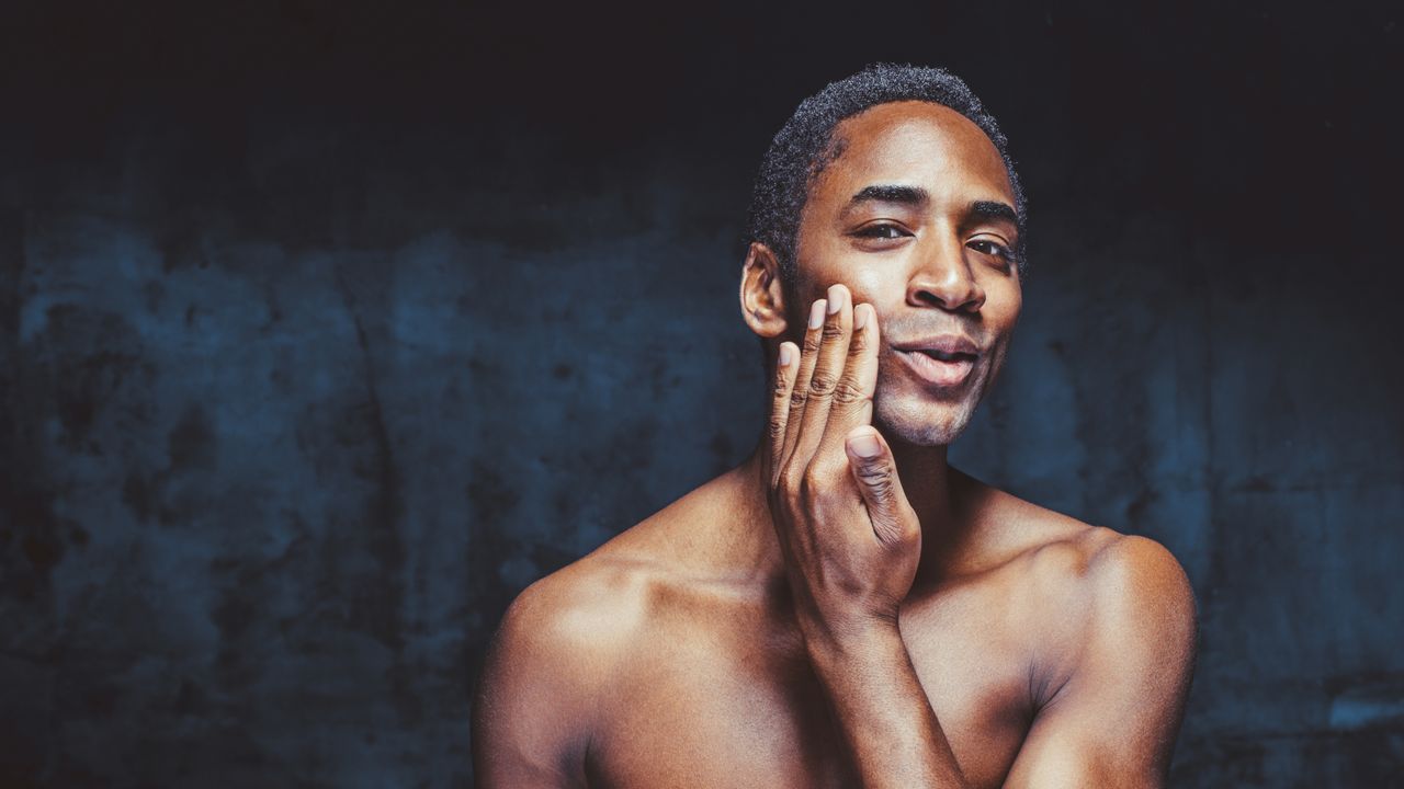 Man applying the best moisturiser for men to his face in the mirror