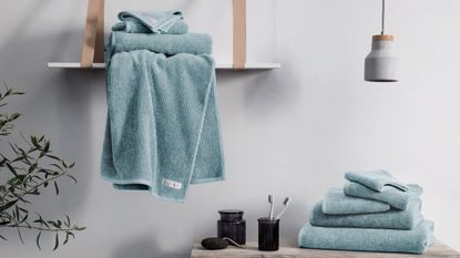 Blue towels on wood table and shelf in bathroom