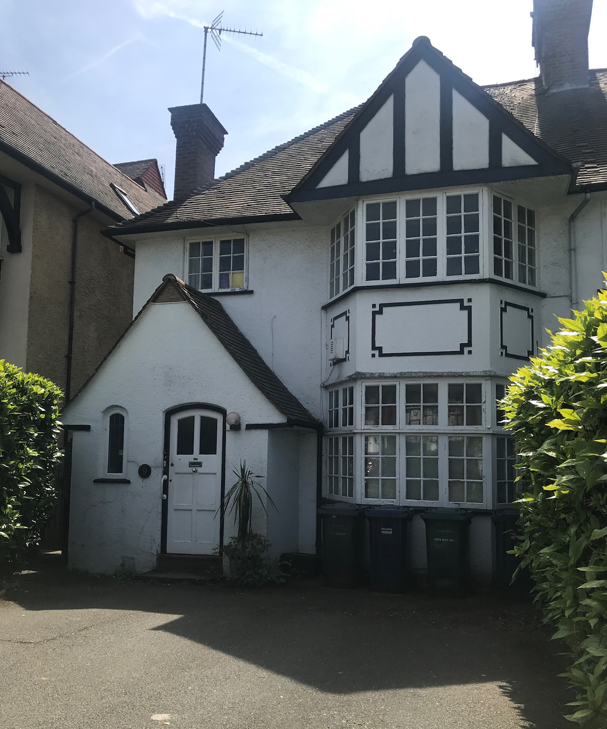 The front of a 1920s home with large bay windows