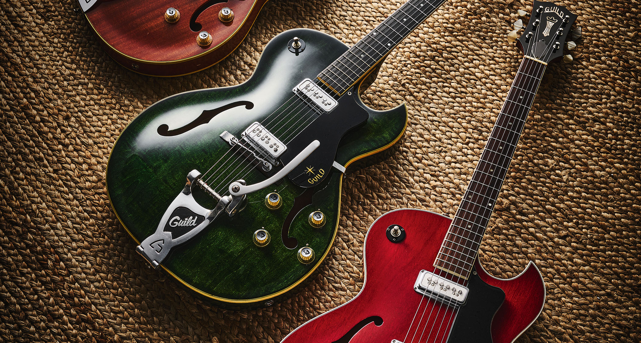 Top to bottom: a 1962 Guild Starfire II in Honey Amber, 1961 Emerald Green-finished Guild Starfire III, and a 1961 Cherry Red Starfire III with a laminated maple top