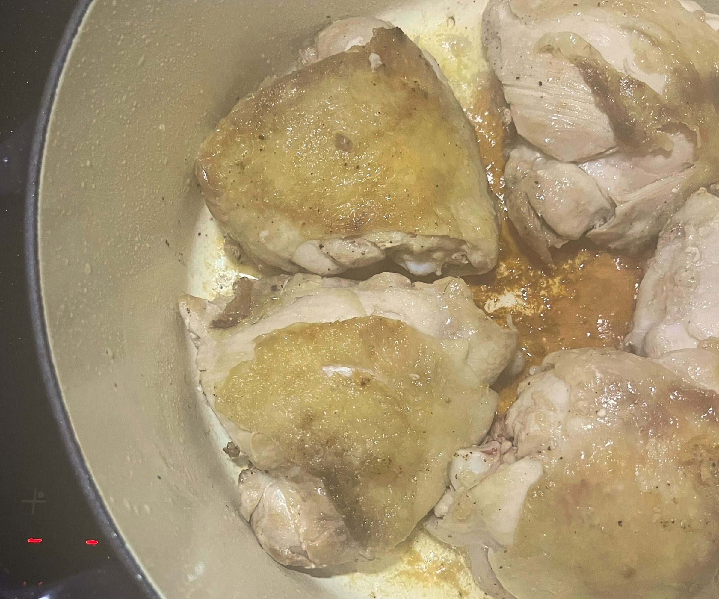 Chicken thighs browning in a Dutch oven
