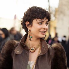 Grown-out pixie: Taylor Hill wears green top, brown leather jacket with fur sleeves, brown trousers, gold decorated jewellery outside the Chloe fashion show during the Womenswear Fall/Winter 2025/2026 as part of Paris Fashion Week on March 06, 2025 in Paris, France