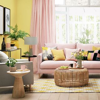 Small living room with pink sofa and curtains and yellow walls