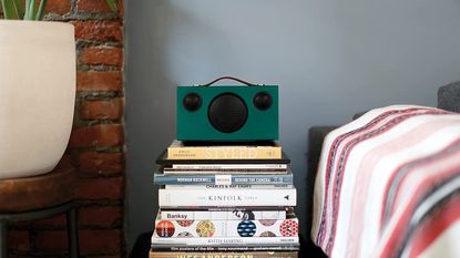 Audio Pro Addon T3+ in green positioned on stack of books