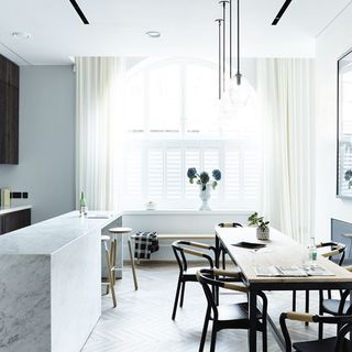 kitchen dinner room with marble worktop and table with chairs and white window