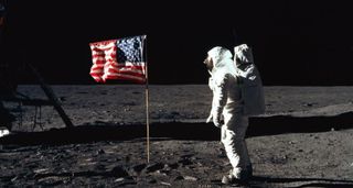 a NASA astronaut stands before the American flag