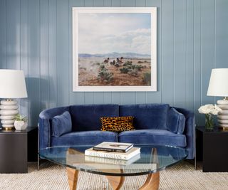 blue panelled living room with a navy couch and large western photograph art