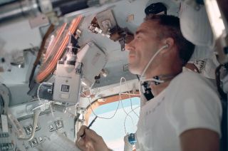 Apollo 7 lunar module pilot Walter Cunningham works inside the command module during the 11-day October 1968 mission.