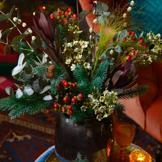christmas flower arrangement sitting on a small coffee table on top of a patterned rug