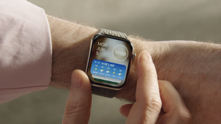 watchOS 10-widgets på en klocka som bärs av en man.
