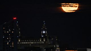 The Buck Moon supermoon shines through dark clouds over Liverpool's historic docks and the Liver Building on July 3, 2023.