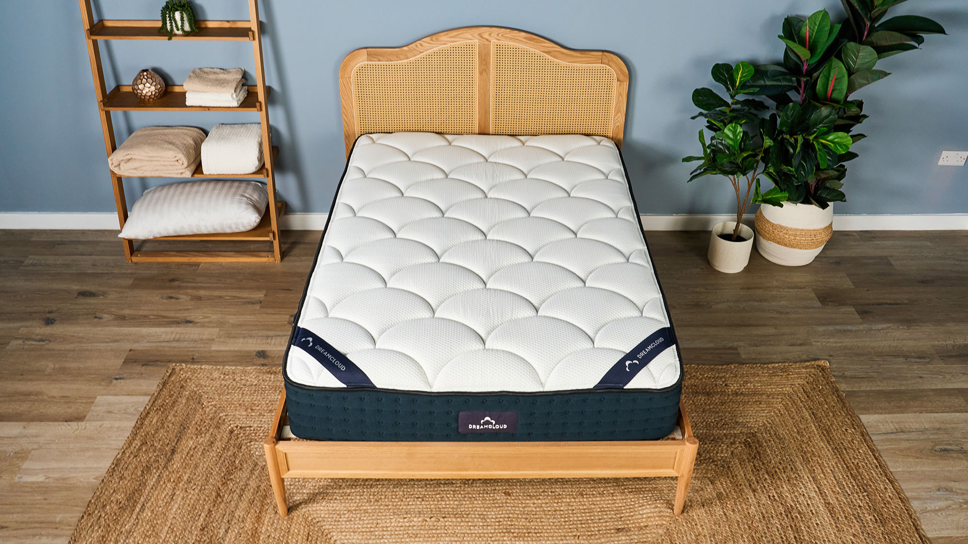 The DreamCloud Hybrid Memory Foam Mattress on a bed frame in a bedroom, shot from above