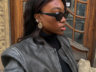 Nnenna Chem in black cat-eye sunglasses and gold jewelry.