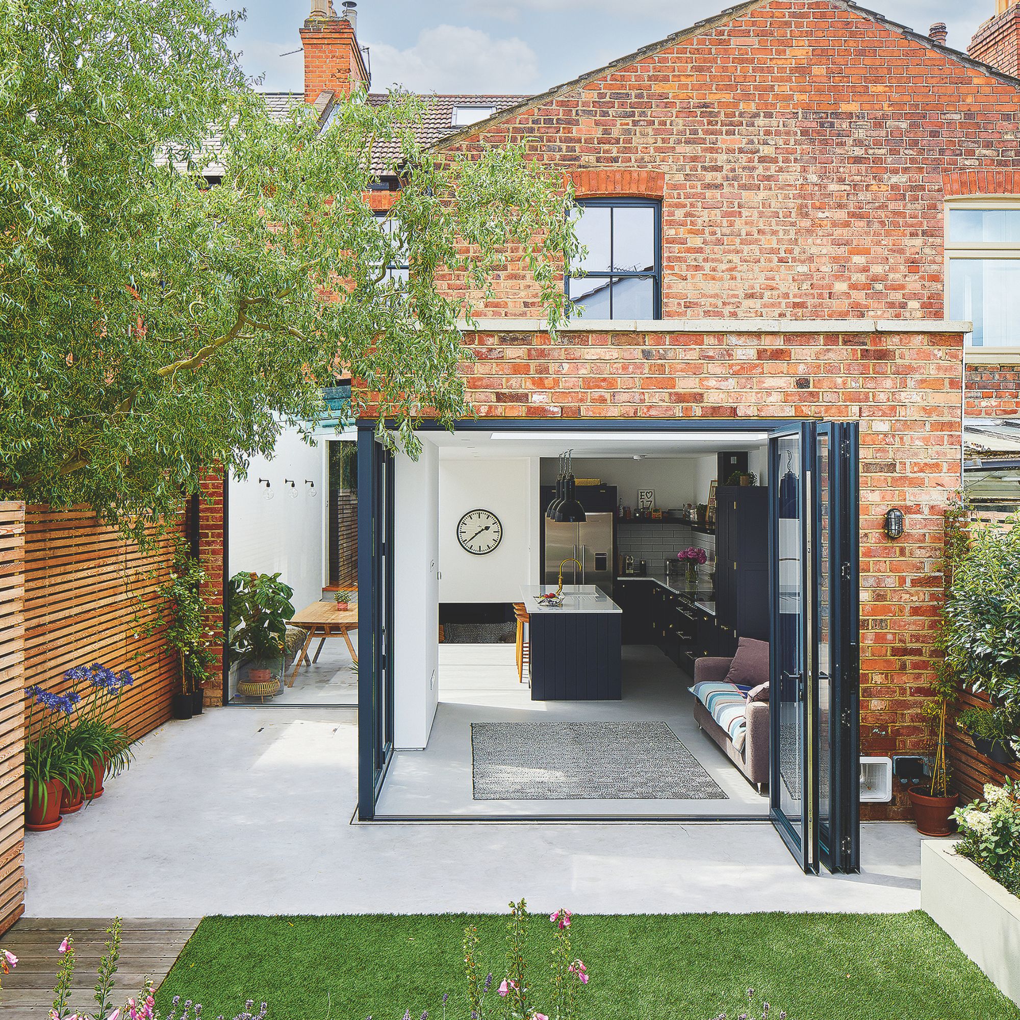 Period house with modern extension out into the back garden, with the large bi-fold doors open
