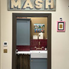 looking through the door at a kitchen with framed art placed on the wall