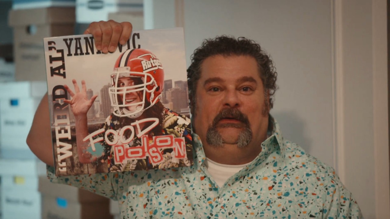 アルバムを掲げるラスティ役のボビー・モイニハン 