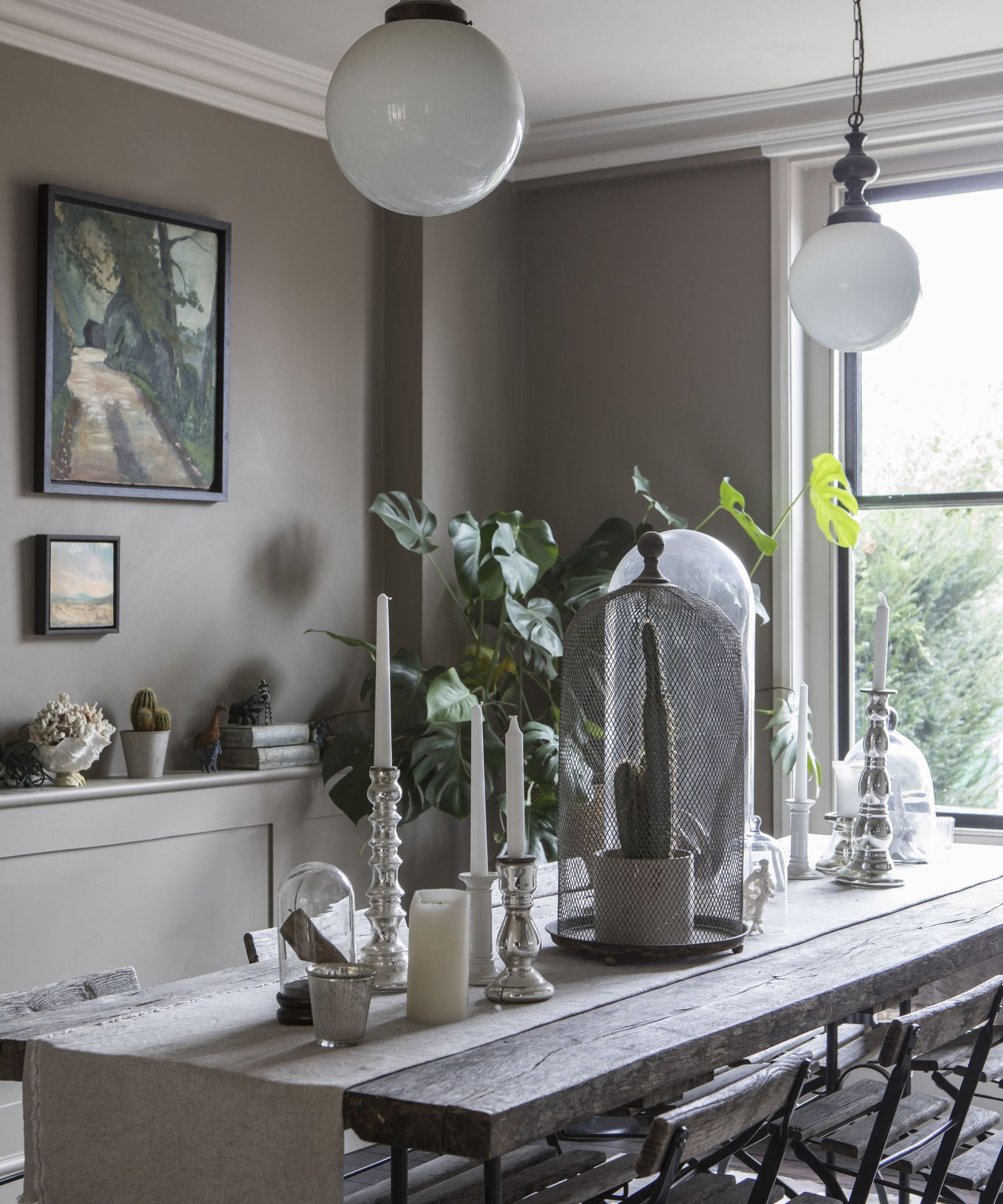 Wooden table, cactus, candles, black framed windows