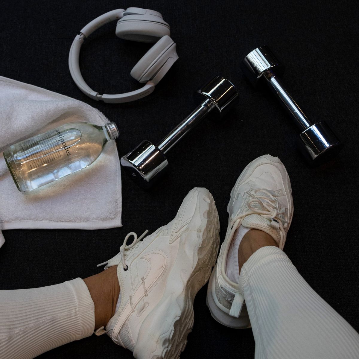 A woman working out in the gym and drinking a green juice