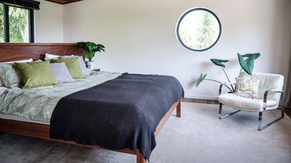 Neutral bedroom with rattan headboard and large matching bedside lamps