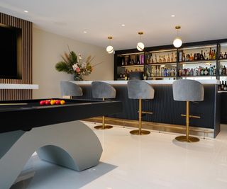 contemporary games room with bar area, stools and modern pool table