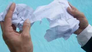 Wet paper tears apart in man's hands.