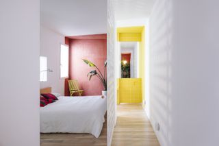 A bedroom and passageway both painted in dark tones