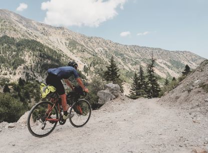 Riding on a gravel track in the mountains on the 2023 Transcontinental Race