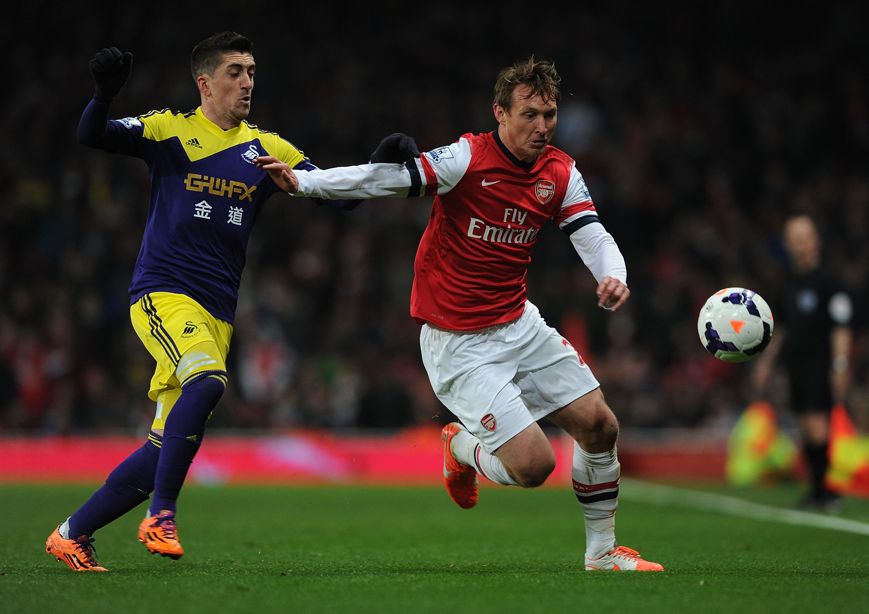 Arsenal's Kim Kallstrom (right) holds off Swansea's Angel Rangel in a Premier League game in 2014.