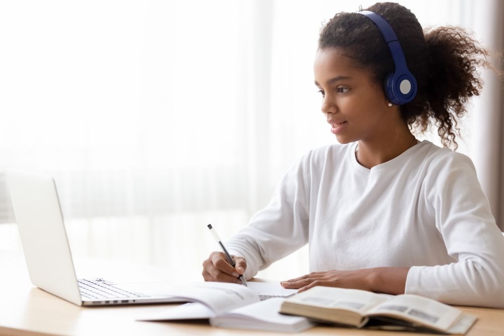 Young girl doing homework with laptop