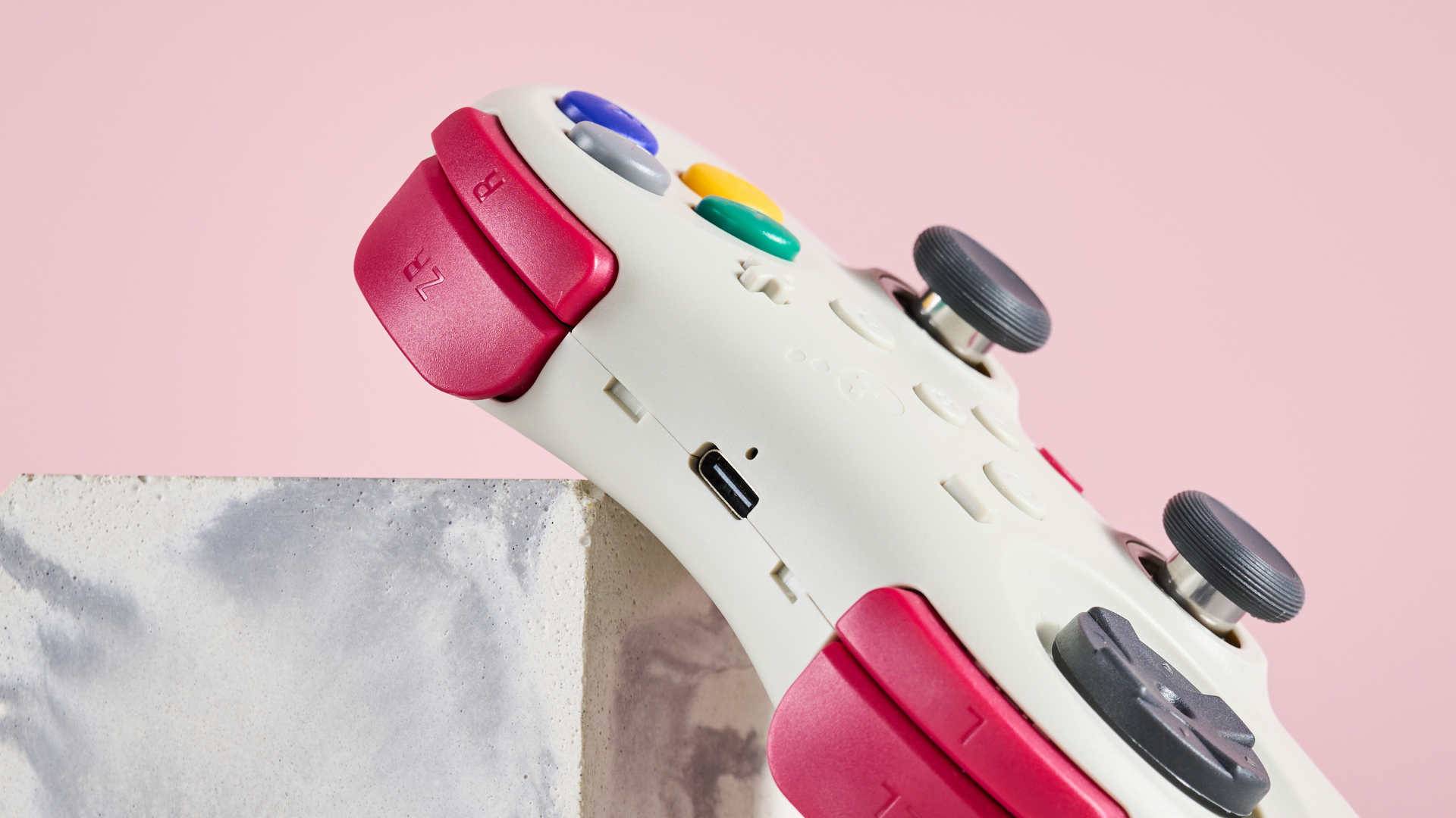 View of shoulder buttons on GuliKit Elves 2 Pro, leaning on plinth with pink background