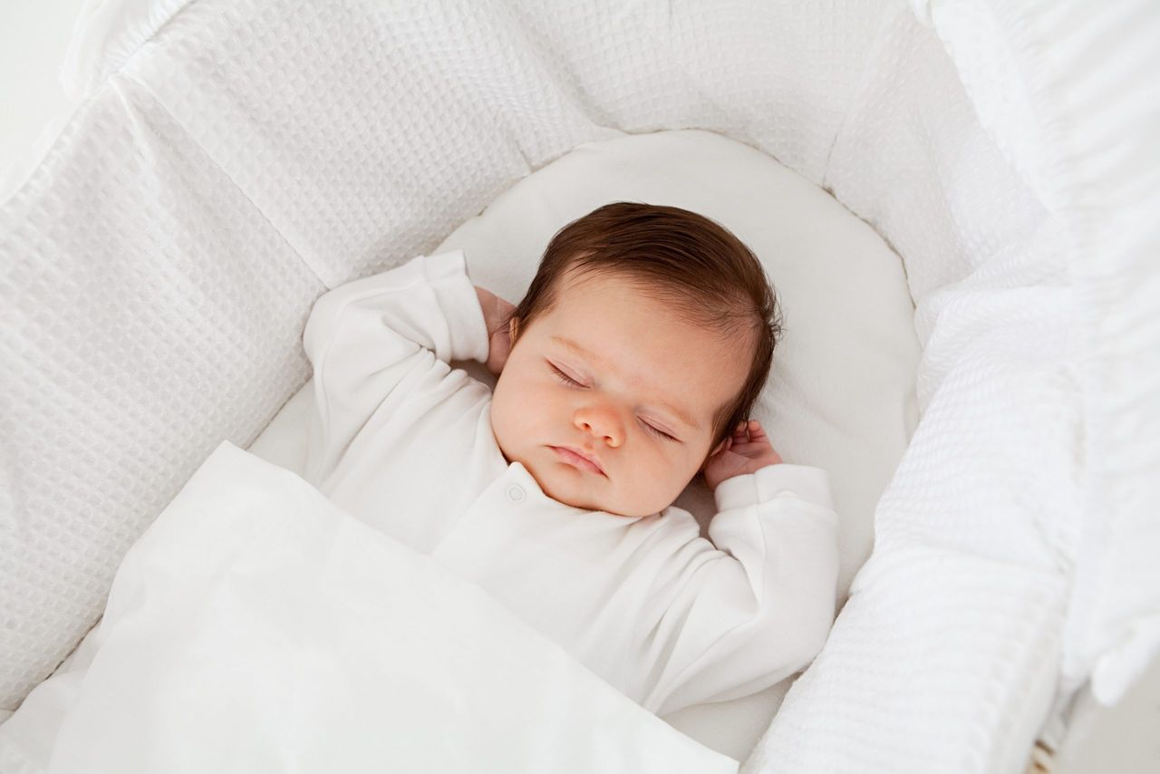 sleeping baby in Moses basket